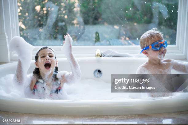 siblings enjoying in bathtub at home - brothers bathroom stock-fotos und bilder