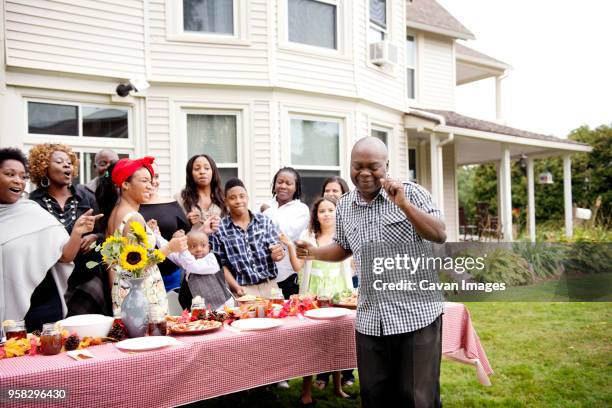 family and friends enjoying at picnic table - familientreffen stock-fotos und bilder