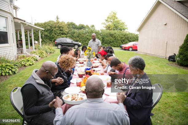 family and friends eating food at picnic table - black family reunion stock pictures, royalty-free photos & images