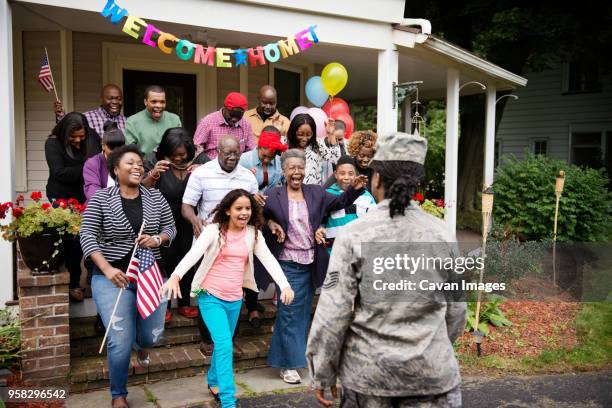 family and friends welcoming female solider - homecoming photos et images de collection