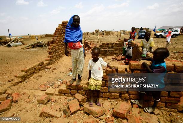 Displaced children play next to half-built shelter at a camp for Internally Displaced Persons near Kadugli, the capital of Sudan's South Kordofan...