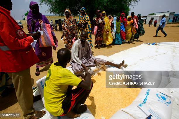 Displaced Sudanese people collect aid at a camp for Internally Displaced Persons near Kadugli, the capital of Sudan's South Kordofan state during a...