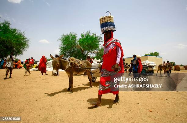 Displaced woman carries a basket at a camp for Internally Displaced Persons near Kadugli, the capital of Sudan's South Kordofan state, during a...