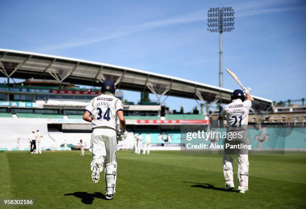 Johnny Bairstow and Jack Leaning make their way out to bat during day four of the Specsavers County Championship Division One match between Surrey...