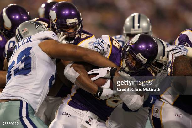 Running back Adrian Peterson of the Minnesota Vikings fights to hold onto the ball against Anthony Spencer of the Dallas Cowboys during the first...
