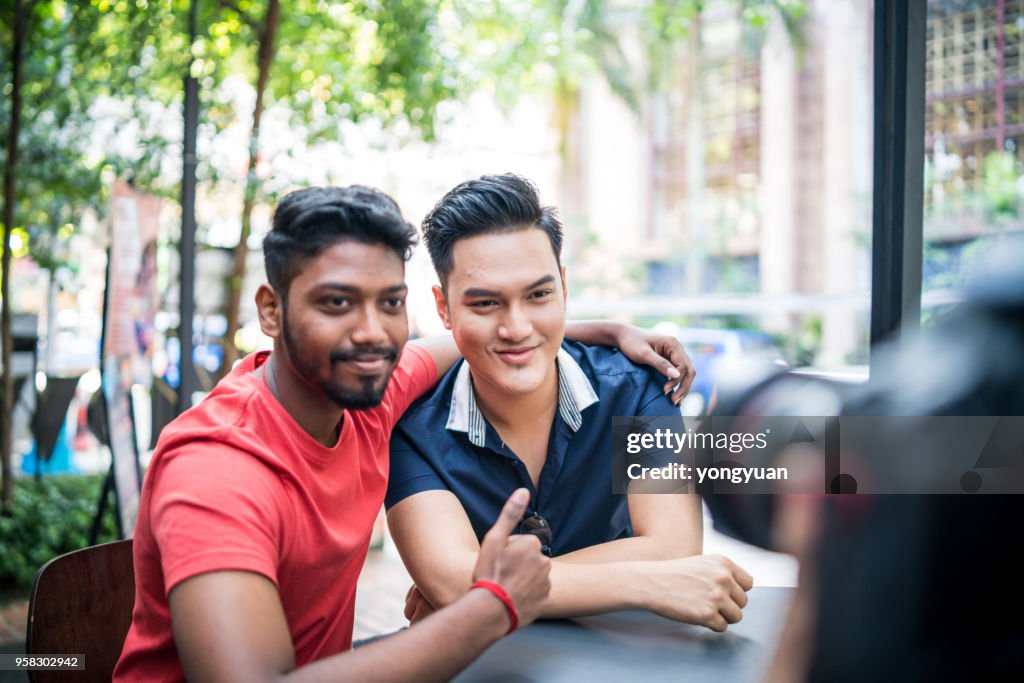 Two cheerful Malaysian young men being photographed