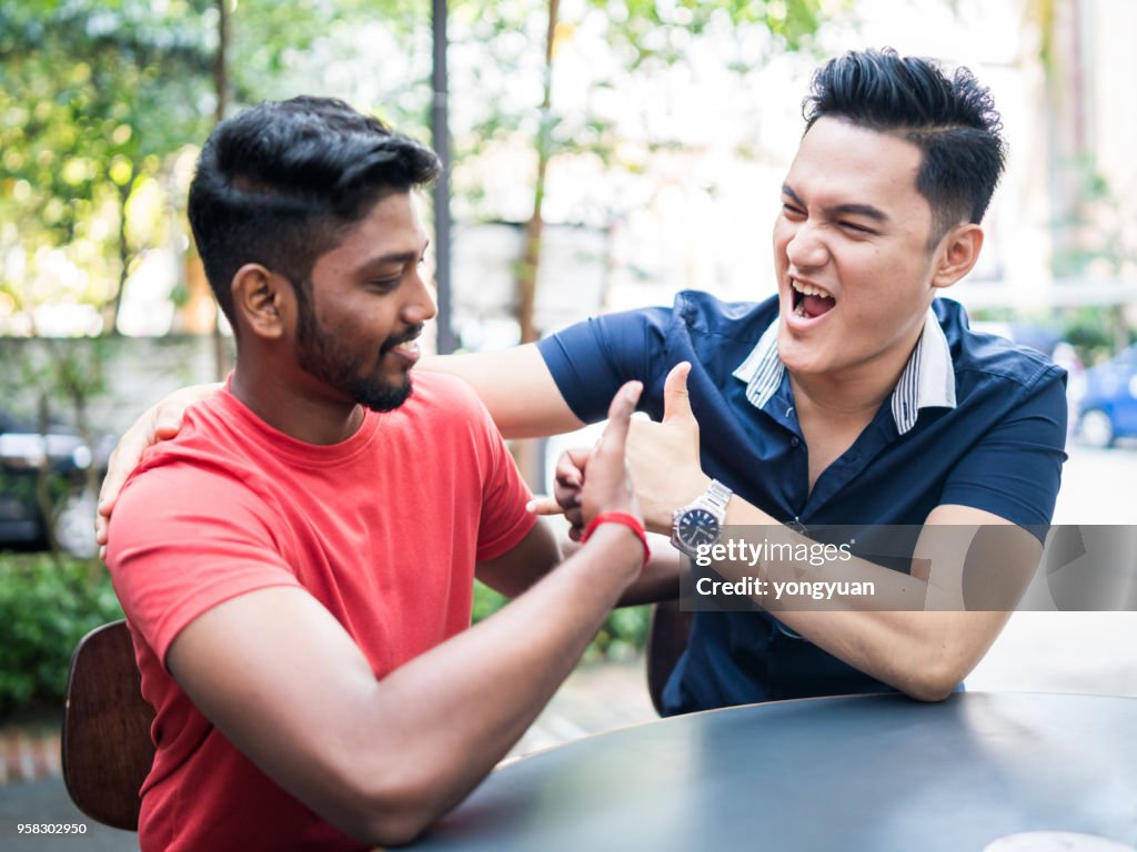 Young men celebrating with thumbs up