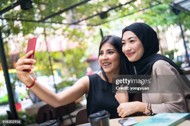 two malaysian girls taking a selfie - yongyuan stock pictures, royalty-free photos & images