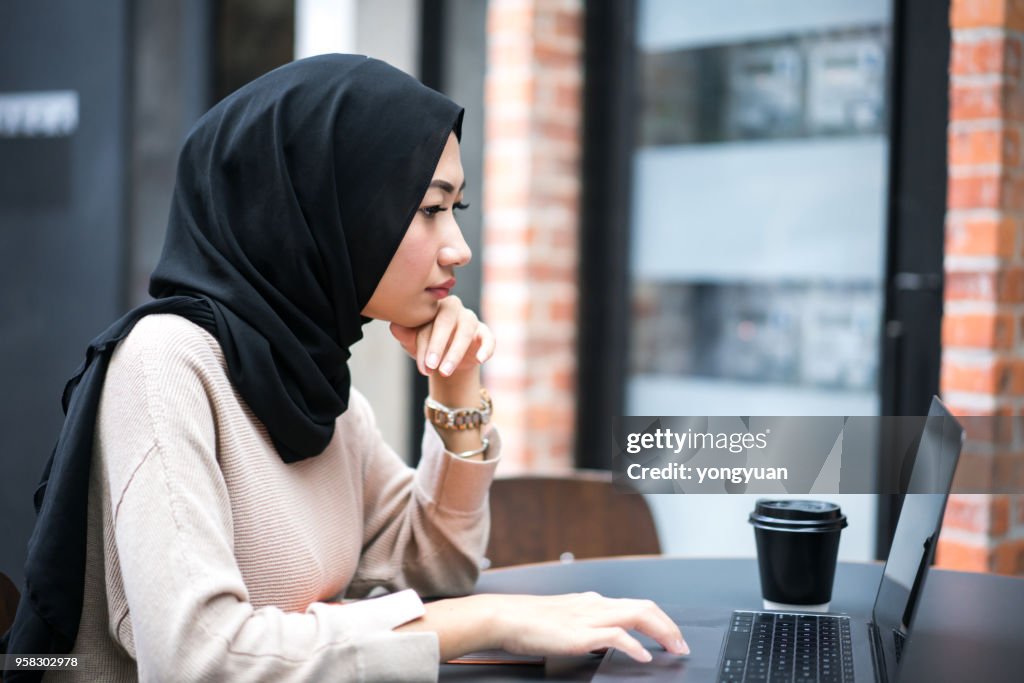 Young Muslim woman working on her laptop
