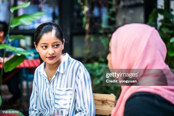 two young woman having a talk - yongyuan stock pictures, royalty-free photos & images