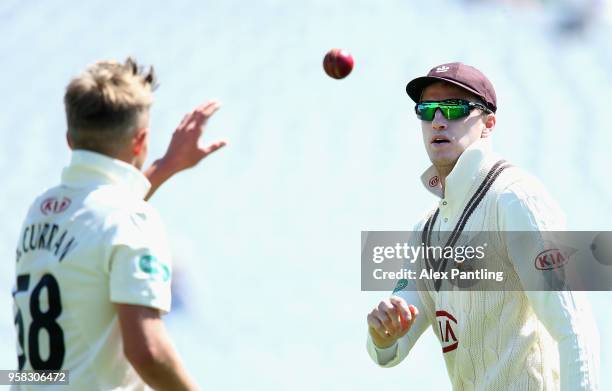 Morne Morkel of Surrey passes the ball to Sam Curran during day four of the Specsavers County Championship Division One match between Surrey and...