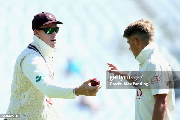 Morne Morkel of Surrey passes the ball to Sam Curran during day four of the Specsavers County Championship Division One match between Surrey and...