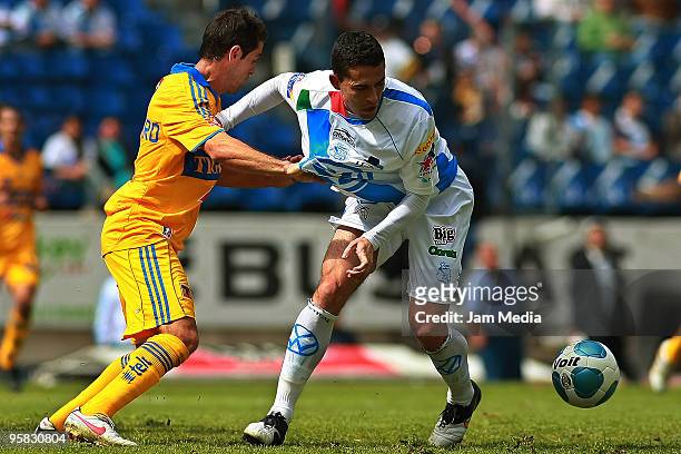 Herculez Gomez of Puebla vies for the ball with Antonio Castro of Tigres during a match as part of the 2010 Bicentenary Tournament in the Mexican...