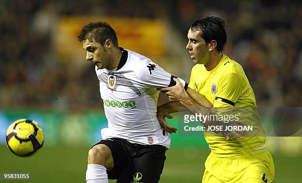 Valencia's midfielder Joaquin Sanchez vies for the ball with Villarreal's Uruguayan defender Diego Godi­n during their Spanish league football match...