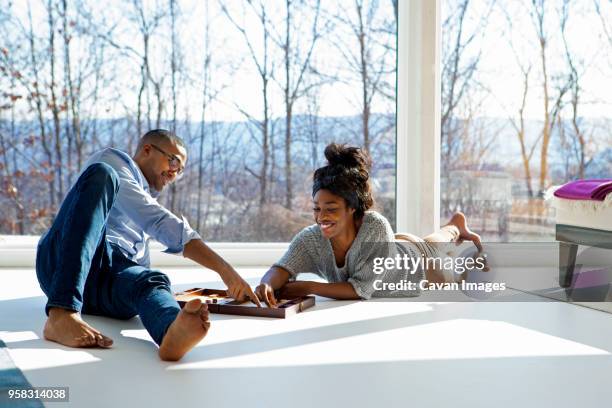 couple enjoying backgammon game at home - dating game stock pictures, royalty-free photos & images