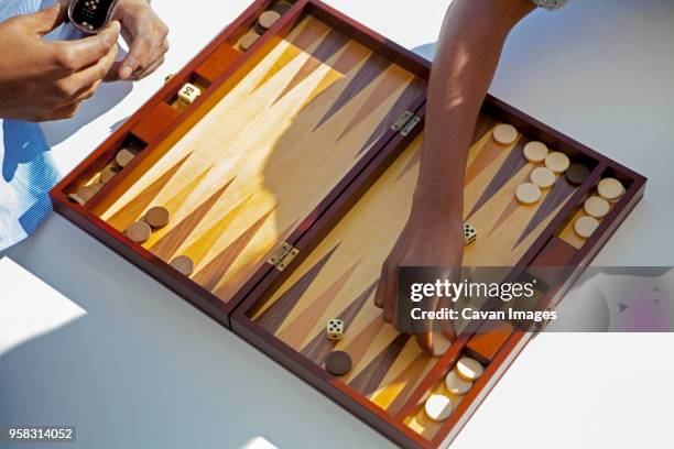 cropped image of couple playing backgammon at home - backgammon stock pictures, royalty-free photos & images