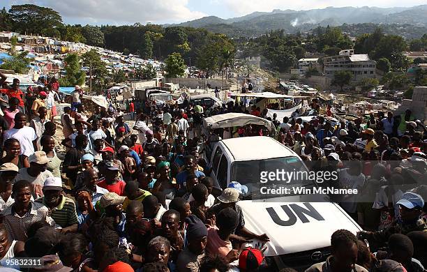 Vehicle is surrounded by residents of the Petinville neighborhood of Port-au-Prince where massive tent villages have risen during a distribution of...