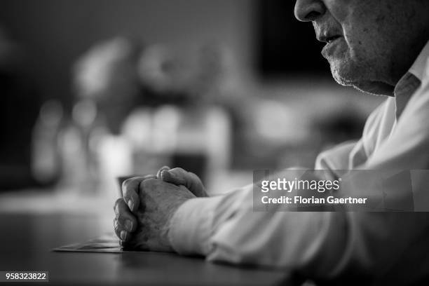 Image has been converted to black and white.) BERLIN, GERMANY An old man sits alone at a table. His hands lay on an old photo on April 27, 2018 in...