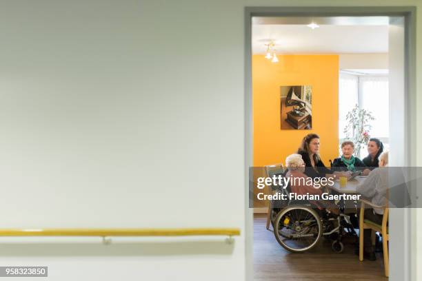 Residents of a nursing home sit with carers in a common room on April 27, 2018 in Berlin, Germany.