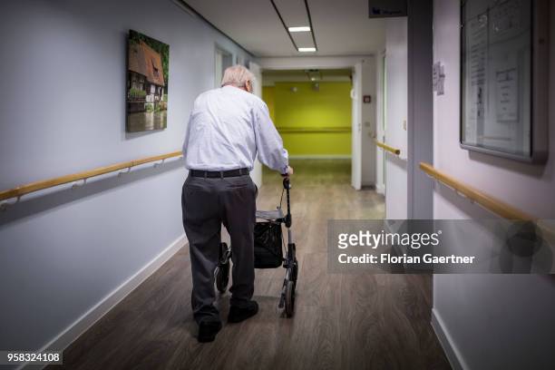 An old man walks with a walking frame through the corridor of a care facility on April 27, 2018 in Berlin, Germany.
