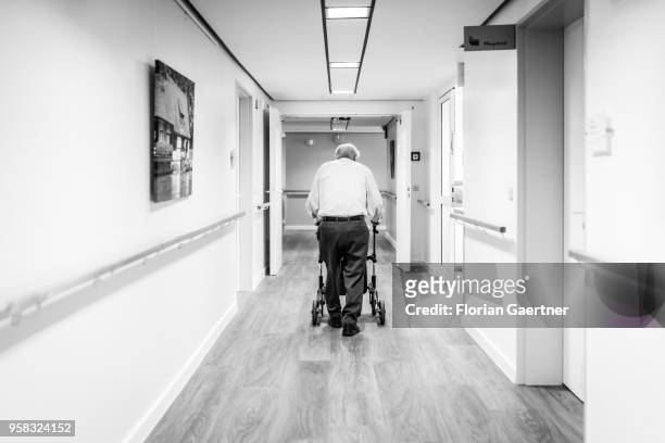 Image has been converted to black and white.) BERLIN, GERMANY An old man walks with a walking frame through the corridor of a care facility on April...