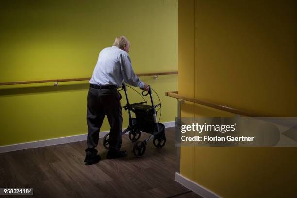 An old man walks with a walking frame through the corridor of a care facility on April 27, 2018 in Berlin, Germany.