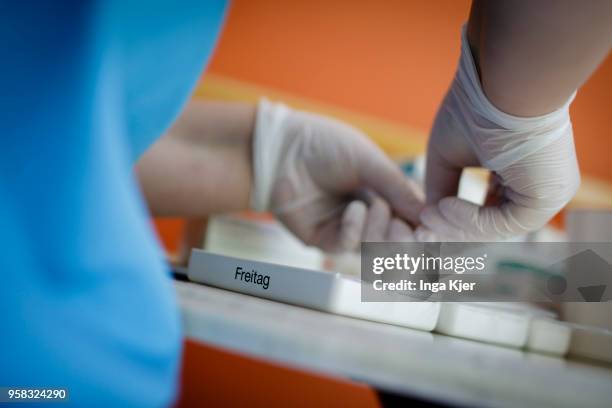 Nurse sorts drugs into tablet dispensers on April 27, 2018 in Berlin, Germany.