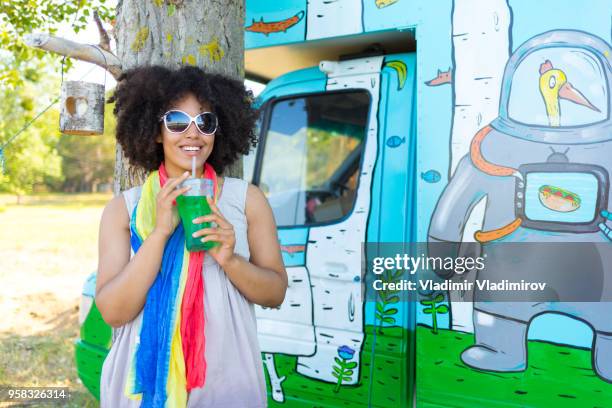 smiling african woman drinking green cocktail - food truck festival stock pictures, royalty-free photos & images