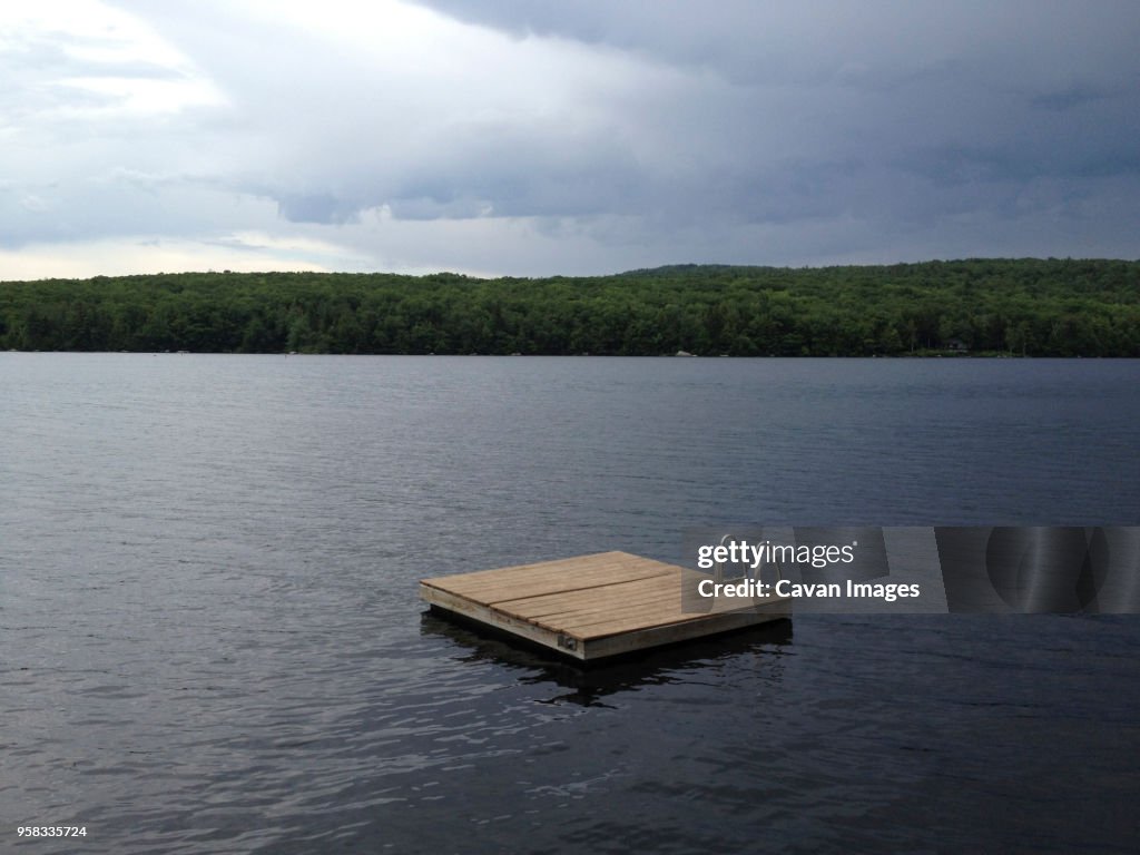Floating platform on lake against cloudy sky