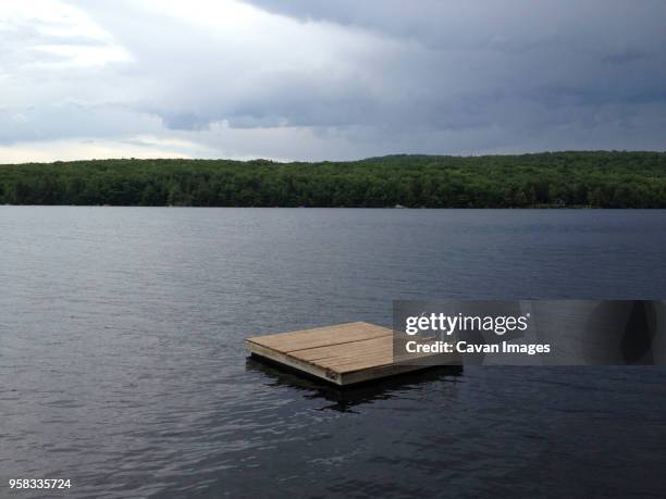 floating platform on lake against cloudy sky - plataforma ancorada flutuante imagens e fotografias de stock