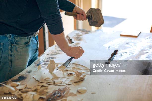 midsection of male carpenter chiseling wood in workshop - chisel fotografías e imágenes de stock