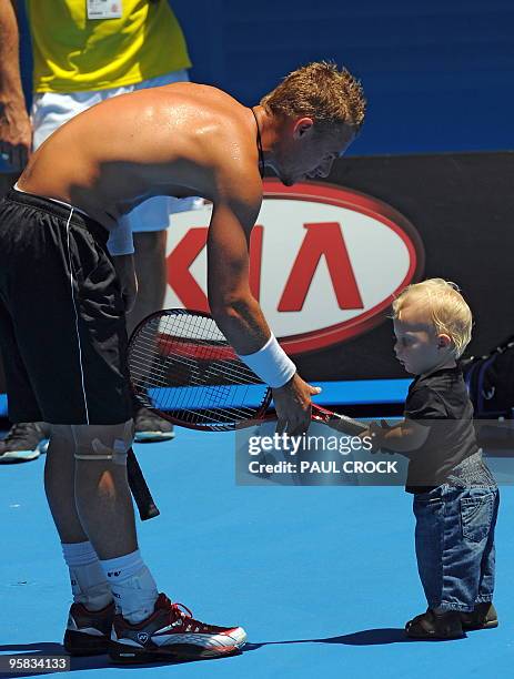 Lleyton Hewitt of Australia takes a break with his son Cruz during a practice session in the lead-up to the Australian Open tennis tournament in...