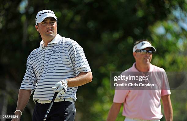 Ryan Palmer watches his tee shot on as Robert Allenby of Australia watches during the final round of the Sony Open in Hawaii held at Waialae Country...