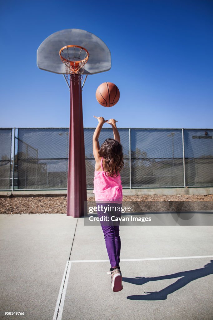 Girl playing basketball on court