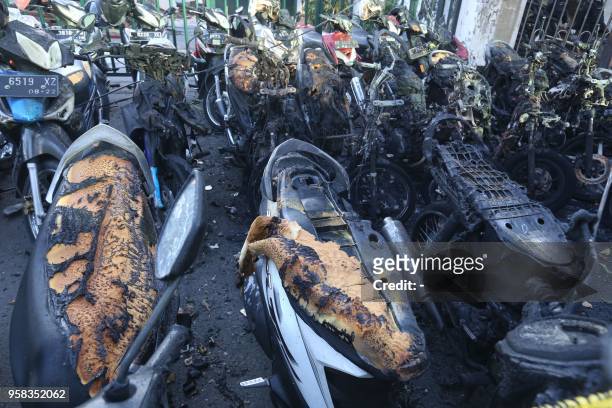 This picture taken on May 13, 2018 shows burnt-out motorcycles following a bomb blast outside the Surabaya Centre Pentecostal Church in Surabaya,...