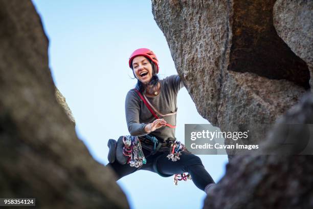 low angle view of happy woman rock climbing - woman challenge stock pictures, royalty-free photos & images