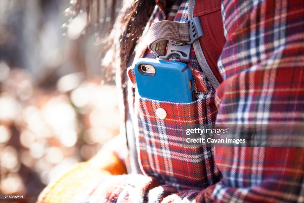 Midsection of woman with smart phone in pocket