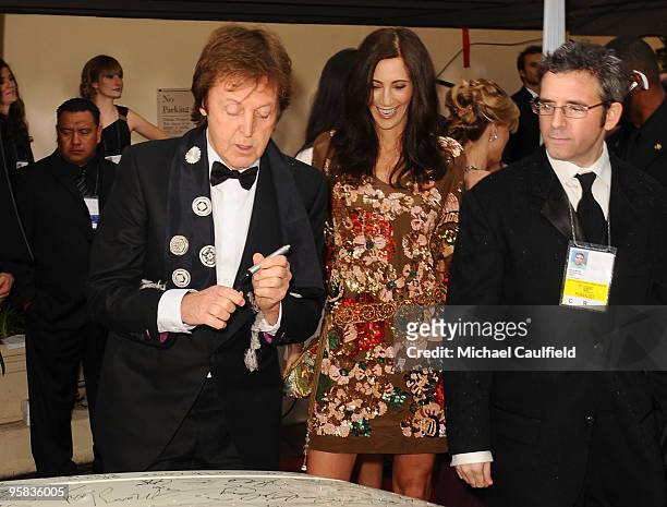 Musician Paul McCartney and Nancy Shevell sign the Chrysler 300 Eco Style car for Stars for a Cause during the 67th annual Golden Globe Awards held...