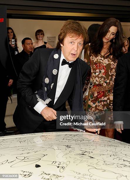 Musician Paul McCartney and Nancy Shevell sign the Chrysler 300 Eco Style car for Stars for a Cause during the 67th annual Golden Globe Awards held...