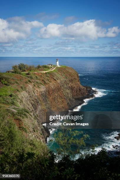 scenic view of mountain by sea against cloudy sky - costa rochosa - fotografias e filmes do acervo