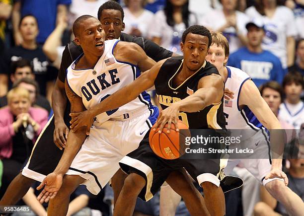 Ishmael Smith and teammate Al-Farouq Aminu of the Wake Forest Demon Deacons keep the ball away from Nolan Smith and Kyle Singler of the Duke Blue...
