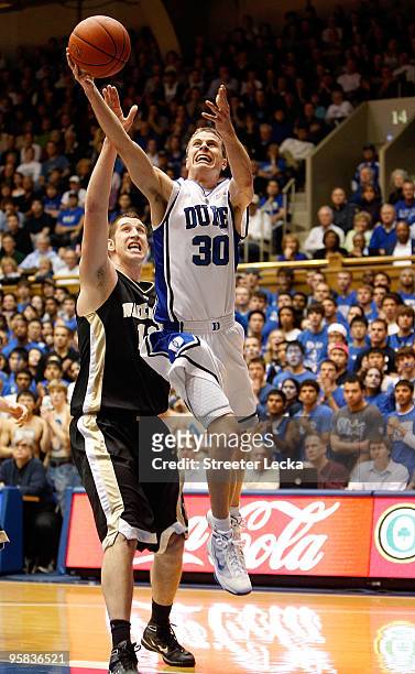 Chas McFarland of the Wake Forest Demon Deacons tries to block Jon Scheyer of the Duke Blue Devils during their game on January 17, 2010 in Durham,...