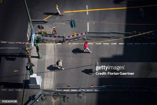 People cross a street through road works on May 09, 2018 in Berlin, Germany.