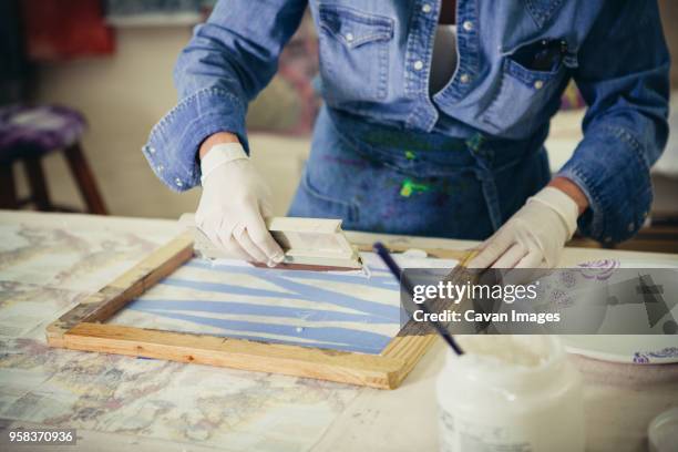 midsection of craftswoman using squeegee while working at workshop - squeegee stock pictures, royalty-free photos & images