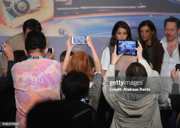 Members of the press take photographs of Leila Bekhti, Marina Fois and Mathieu Amalric during the press conference for "Sink Or Swim " during the...