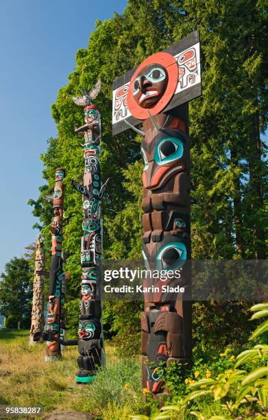 totem poles standing in parkland - stanley park fotografías e imágenes de stock