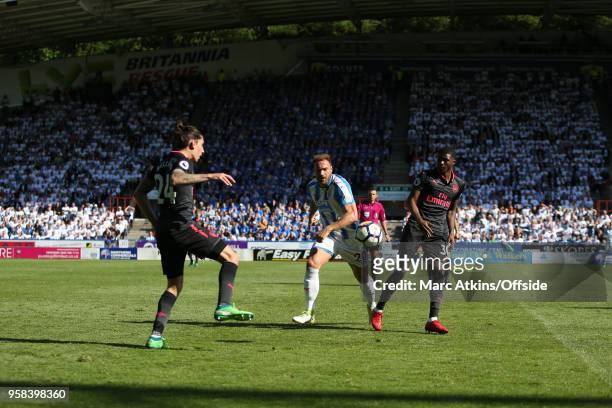 Laurent Depoitre of Huddersfield Town in action with Hector Bellerin and Ainsley Maitland-Niles of Arsenal during the Premier League match between...
