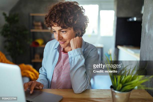 vrouw met behulp van een computer - 40s laptop stockfoto's en -beelden