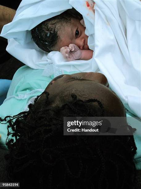 In this handout image provided by the U.S. Coast Guard, a male Haitian newborn lays on his mother aboard the Coast Guard Cutter Tahoma on January 16,...