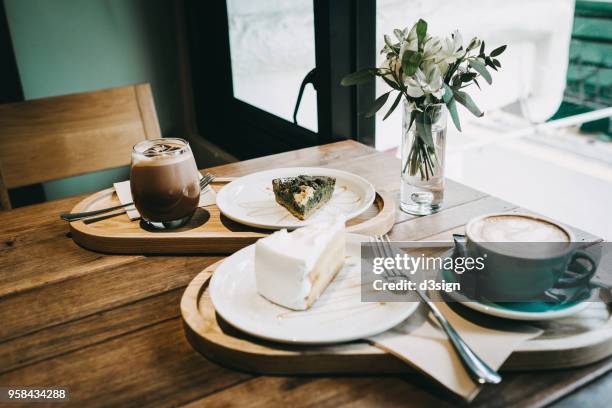 coffee and cakes served on table in cafe by the window - enjoying coffee cafe morning light stock-fotos und bilder